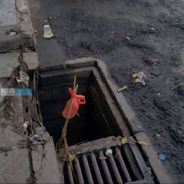 كيس أحمر بدل الغطاء فتحة تصريف مياه تثير سخرية واستياء السكان