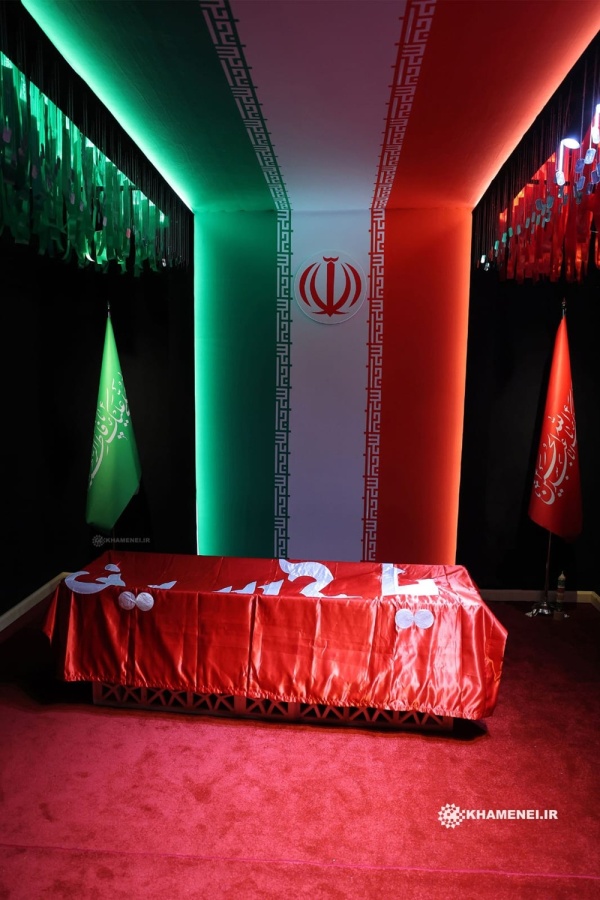 بالصورة راية مقام الإمام الحسين عليه السلام تغطي جثمان سماحة الإمام الشهيد السيد علي الخامنئي