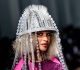grammy award winning singer shows off her baby bump on the paris fashion week runway wowing fans with a chandelier on her head
